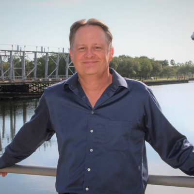 man smiling standing in front of water