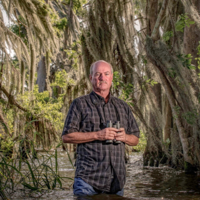 man standing in southern swamp with stoic look on his face