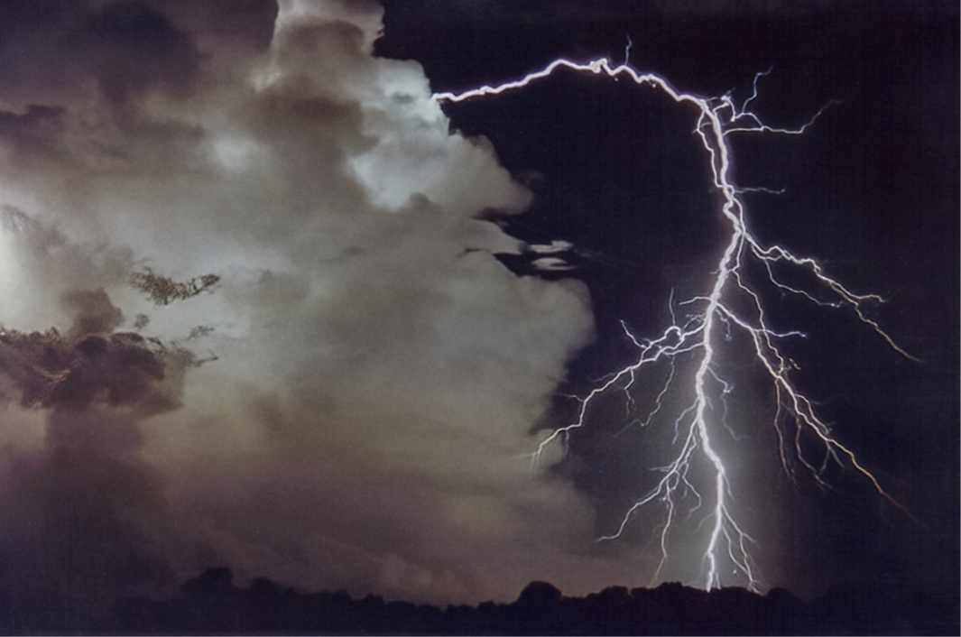 a large lightning bolt arching out of a cloud in the night sky