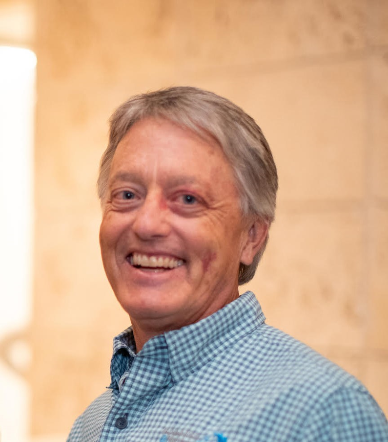 man with salt and pepper hair smiling