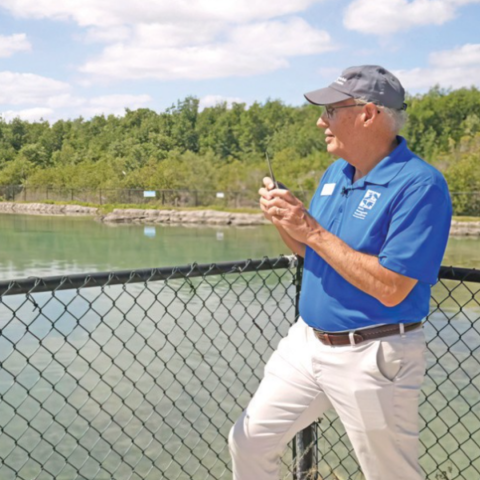 man standing with walkie talkie looking over water